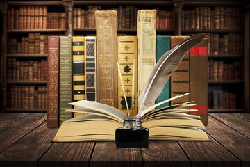 Old books, retro quill pen and inkwell in library.