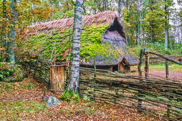 Stone age settlement with a longhouse in a forest at autumn