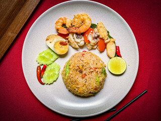 Thai seafood fried rice with shrimp, squid, and mussels stir-fried with jasmine rice, eggs, and aromatic seasonings for a savory flavor.