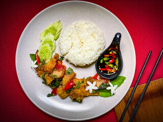 Spicy Thai stir-fry with crispy pork belly and fragrant holy basil, served with rice for a flavorful street food favorite.