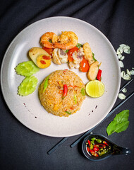 Thai seafood fried rice with shrimp, squid, and mussels stir-fried with jasmine rice, eggs, and aromatic seasonings for a savory flavor.