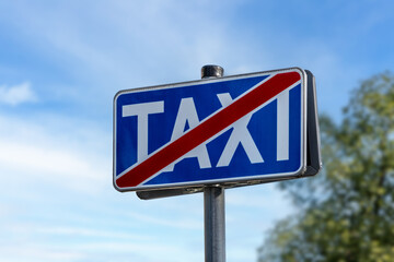 No Taxi Traffic Sign On Street Indicating End Of Taxi Zone Against Blue Sky