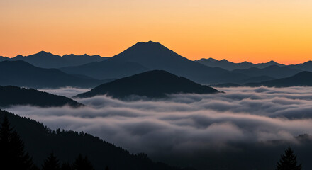 Serene mountain layers emerge from soft clouds under a vibrant orange sunset sky