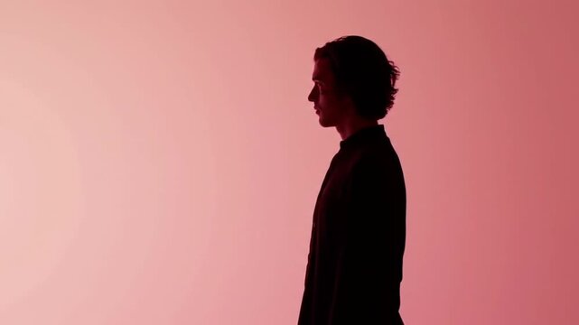 Silhouette of a Man Against Pink Background