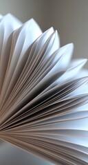 Abstract view a fan-like arrangement of white paper pages, showcasing the repeating curves and edges in crisp detail