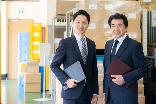 倉庫で会議をするミドルのビジネスマン