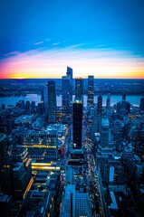 Fototapeta premium Aerial view of New York City skyline at sunset with illuminated skyscrapers