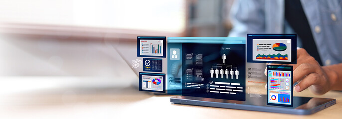 Businessman using tablet with futuristic analytics dashboard and digital data charts overlay. Concept of business intelligence, big data, and digital transformation.