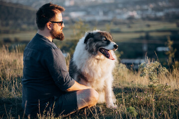 Happy dog and man sitting outdoor