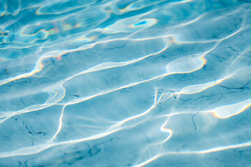 Bright light blue water surface with shimmering wave reflections, abstract liquid texture