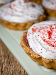 Shortbread mini tart cupcakes filled with strawberry ice cream close up, sweet pink dessert