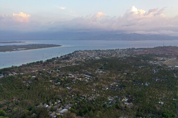 Scenic aerial drone photograph of small tropical islands in the ocean, encircled by coral reefs and clear turquoise water