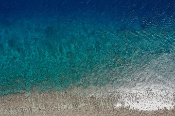 Aerial top-down view of a vibrant ocean reef beneath crystal turquoise water