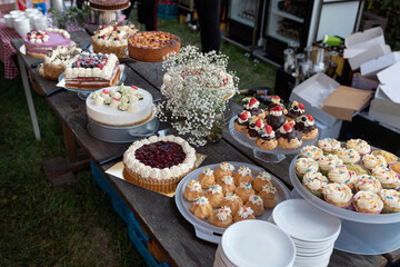 Outdoor catering table with variety of cakes pastries and desserts for event
