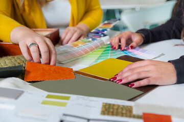 Interior designer working with client choosing colors and materials from sample books