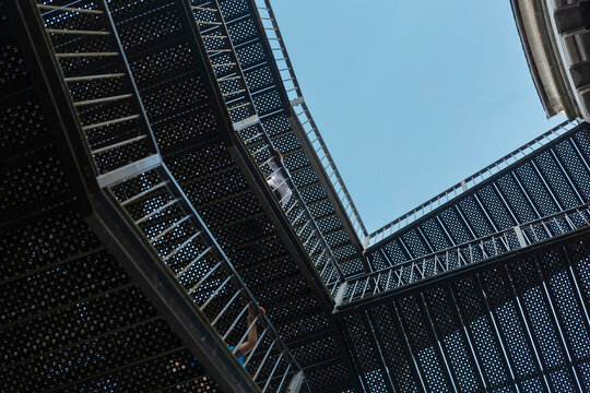 Upward view through modern perforated metal structure showing geometric pattern - Powered by Adobe
