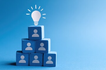 Lightbulb atop a pyramid of light-blue blocks with person icons, on a bright-blue background