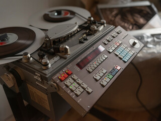 Vintage reel-to-reel tape recorder with control panels and analog meters for music production