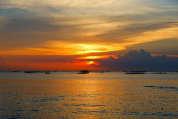 sunset in the sea. Beautiful colorful sky and cloud in twilight time background. Orange fluffy clouds and sun sunlight reflection in the blue sky.