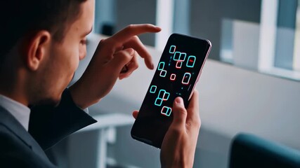 Young man in suit with smartphone displaying virtual reality interface with red and blue geometric shapes against blurred modern office background. Virtual reality and mobile technology concept. - Powered by Adobe