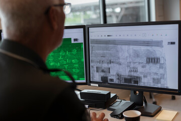 Security operator using advanced scanning technology with multiple displays for border inspection