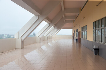 An empty and elegant corridor in a modern building with tiled floors and a homely design.