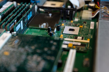 Close-up of server motherboard displaying CPU heatsink capacitors and electronic components for...