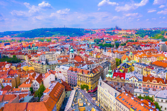 Fototapeta Drone photo of Prague cityscape with historic rooftops, church spires, winding streets and the panoramic skyline of the Czech capital under clear sunny skies in summer