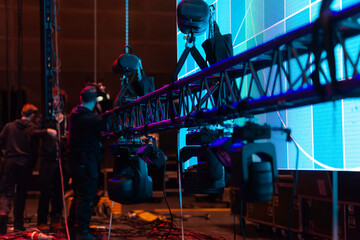 Broadcast camera operators working on elevated platform with LED screens in background