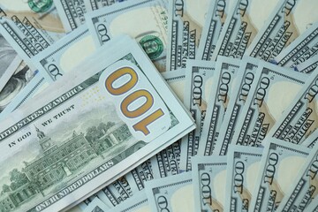 Many hundred dollar bills new banknotes in big pile under the natural light