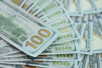 Many hundred dollar bills new banknotes in big pile under the natural light