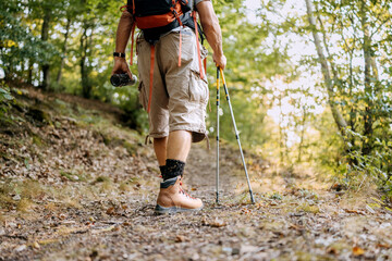 Senior individuals enjoying a hiking adventure through a beautiful wooded trail surrounded by...
