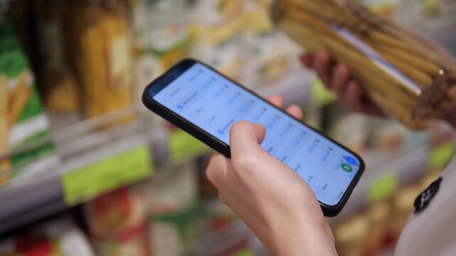 Hands hold eco-friendly breadsticks and a phone with a partially checked shopping list, emphasizing conscious consumerism. Perfect for sustainability, health, or grocery hauls.
