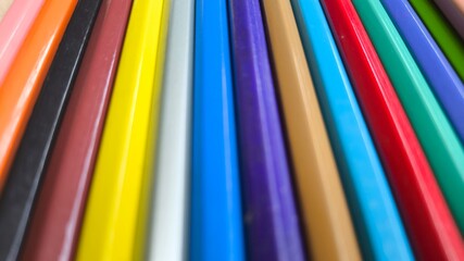 Assorted colored pencils arranged on right side of frame. Vibrant stationery elements creating a beautiful artistic background. Flat lay image with copy space and educational theme.