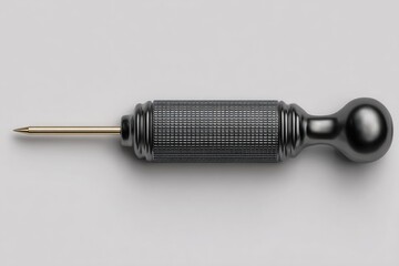 Dark gray tool, cylindrical,  with gold tip,  lying flat