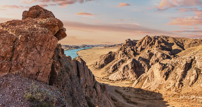 Scenic view of Ili River meandering through a canyon with dramatic rock formations at sunset, creating a breathtaking landscape in Kazakhstan