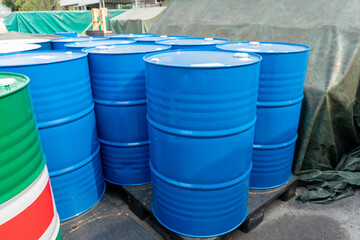 Blue industrial steel drums arranged outdoors near a warehouse, used for storing chemicals, oils,...