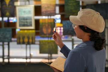 Woman observing artwork in modern art gallery. Captures moment of thoughtful appreciation, ideal for themes of creativity, inspiration, education, and cultural exploration.