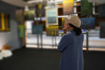 Woman observing artwork in modern art gallery. Captures moment of thoughtful appreciation, ideal for themes of creativity, inspiration, education, and cultural exploration.