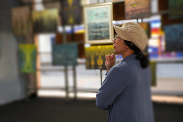 Woman observing artwork in modern art gallery. Captures moment of thoughtful appreciation, ideal for themes of creativity, inspiration, education, and cultural exploration.