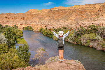 Tourist with a backpack admiring the breathtaking views of the Charyn river and canyon in Kazakhstan, embracing the spirit of adventure