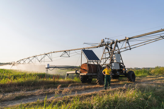 Farmer using digital tablet by pivot irrigation tractor with solar panel