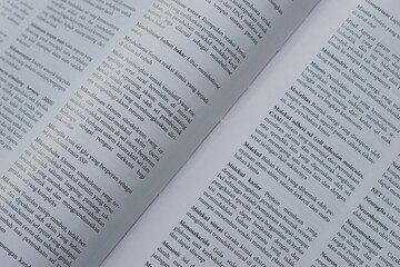 Obraz premium A close-up of an open medical textbook, showing detailed text and diagrams about human physiology and biology. This image represents study, education, research, and the journey of a medical student.