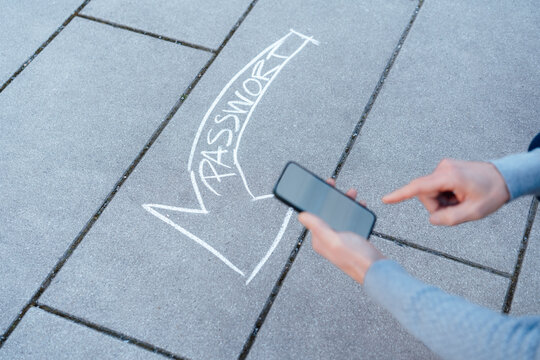 Man using smart phone with text arrow on footpath in background