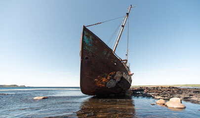 old wrecked sunken ship on the rocky shore of the Arctic Ocean