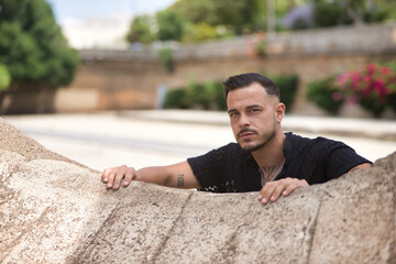 Portrait of young, brunette, Hispanic, modern man in black crochet shirt, with serious and defiant...