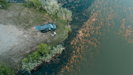 Overhead view of van life in Bavaria mini camper parked by a clear lake with mountains nature freedom and adventure