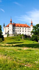Obraz premium Castle on a hilltop in lush green landscape