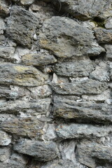 Close-up of an old stone wall, highlighting the varied shapes, textures, and colors of the rocks and mortar. A perfect texture background or detail shot.