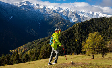 Happy asian man walking on grass with hiking poles as enjoying nature view in Hiking the mountains...